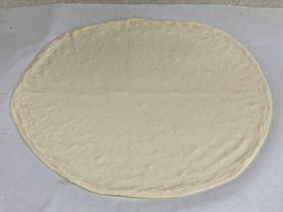 18、黑椒牛肉披萨,把面饼移到油纸上或者披萨盘内表面用叉子扎孔