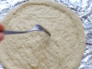 4、香蕉芒果披萨——九寸,烤盘中铺锡纸放入饼皮，也可以放进披萨盘，用叉子在饼皮上面扎一些小眼，防止烤制的时候饼皮鼓起来