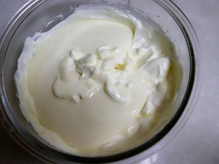 11、樱花芝士慕斯,把奶油奶酪倒入淡奶油中，用刮刀翻拌均匀。