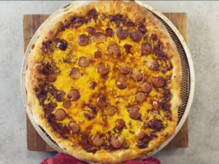 4、车打芝士披萨【披萨的做法】,然后均匀挤上芝士酱，撒上火腿片。