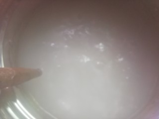 7、自制开心凉粉,将搅拌均匀的豌豆淀粉糊糊缓慢的倒入开水中，并调小火，期间不停的搅拌锅中的水，以免粘锅。