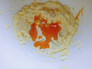 8、#万圣节#女巫手指饼干,加入蛋黄液，再次启动电动打蛋器，充分打至蛋黄液和黄油融合。