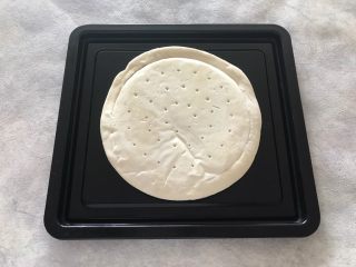 1、早餐番茄酱火腿鸡蛋披萨,披萨饼皮放入烤盘