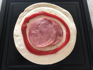 3、早餐番茄酱火腿鸡蛋披萨,如图所示,挤上适量番茄酱