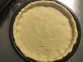 6、秘制芝心卷边披萨,将饼皮移入披萨盘内，没有披萨盘就放烤盘里。