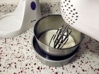 8、心形火龙果慕斯,淡奶油加入糖粉,盆底坐一盆冰水,中速打发。