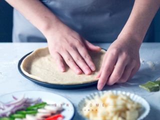 10、麻辣小龙虾披萨,用手慢慢调整面饼与披萨盘贴合后，封上保鲜膜室温发酵15分钟（冬天气温低发酵时间至少需要30分钟）；