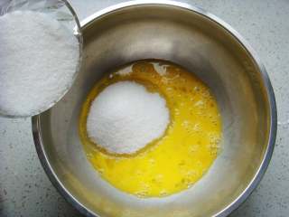 2、芝麻桃酥,鸡蛋倒入大盆中用筷子打撒，倒入绵白糖。（绵白糖易融化，如果是白砂糖就用料理机打成粉）