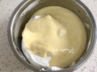 7、肉松小贝,把拌好的蛋黄糊倒入蛋白霜盆里，用刮刀翻拌均匀。