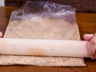 2、【免烤箱蛋糕】零失败芒果慕斯蛋糕,将消化饼干用擀面杖碾碎