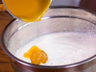 10、【免烤箱蛋糕】零失败芒果慕斯蛋糕,将淡奶油和芒果溶液混合,用刮刀翻拌均匀。即成芒果慕斯液。