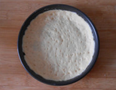 3、培根披萨,披萨盘涂黄油，发酵好的面团擀成圆形，放入披萨盘，压一压，让面皮贴合披萨盘，用叉子叉一些小孔