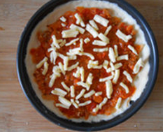 4、培根披萨,铺上番茄肉酱，撒一层马苏里拉芝士，放入预热200度的烤箱，烤10分钟