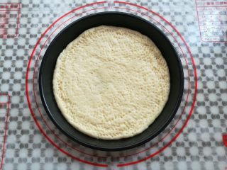 8、缤纷水果披萨,把面团放入抹了油的披萨盘中，在面团上用叉子戳出小洞