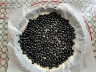 12、缤纷水果披萨,在披萨面团上盖一张锡纸铺满豆子，防止烤的过程中面团膨胀起来