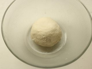 5、十香菜培根披萨,揉好的面团放入容器，盖保鲜膜开始发酵，现在天热，室温即可。