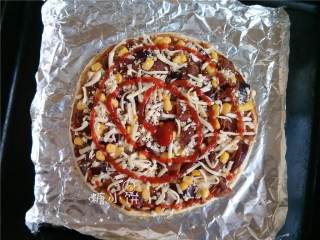 10、烟熏风味BBQ烤鸡肉披萨,撒上剩余分量的芝士碎，零散地挤上番茄酱。表面撒上一点现磨粗粒黑胡椒和干牛至碎。