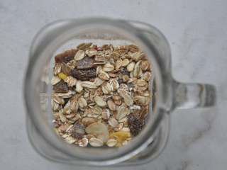 1、早安早餐+营养早餐组合,先来做隔夜的准备工作。杯底铺上一层即食麦片。