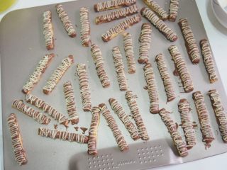 12、巧克力脆棒,将融化的白巧克力放入裱花袋，在饼干上挤上线条，晾凉后凝固即可。