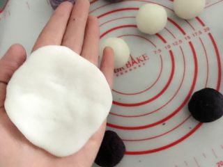 12、紫薯冰皮月饼,用手掌将冰皮压成圆饼，中间厚一点，边缘薄一点。