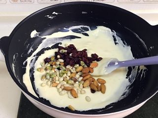 6、坚果雪花酥,关火，加入蔓越莓干、杏仁、花生和开心果，迅速翻拌几下。