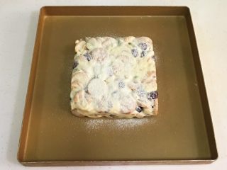 11、坚果雪花酥,给整形好的雪花酥筛上奶粉。