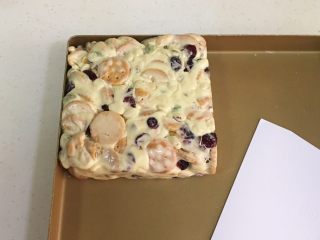 10、坚果雪花酥,带上一次性手套慢慢推压紧实雪花酥团，然后进一步借用塑料刮板整形成方形。