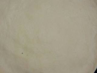 2、培根披萨,烤盘刷油将披萨放入用牙签插孔