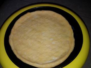 2、妈咪披萨,将烤盘上均匀涂上一层薄薄的食用油，面团摊平在烤盘上（边缘略厚），用叉子扎上小眼