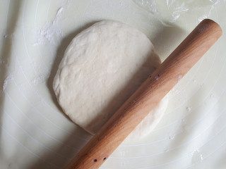 8、~创意披萨☺,案板上撒些面粉，将发酵好的面团擀成比模具略小的圆饼，待用。