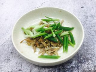 5、凉拌麻辣拆骨肉,把小香葱放入拆骨肉的盘子里。