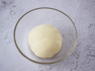 1、杂蔬火腿肠披萨,把饼皮材料放入容器中，揉成光滑的面团即可，做披萨不需要揉出膜，揉圆盖上保鲜膜放温暖处发酵至两倍大