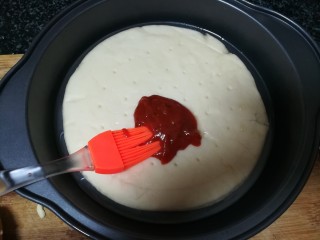 9、绿油油的披萨,好吃不腻,披萨面饼放在披萨盘内，挤出一些披萨酱