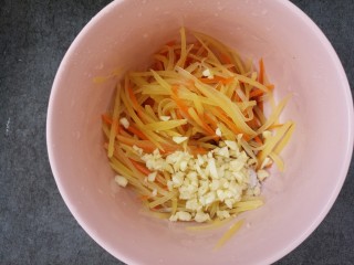 14、凉拌土豆丝胡萝卜丝,把蒜末放进碗里