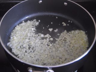 8、披萨酱,倒入蒜末和白洋葱翻炒至香