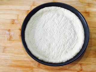 7、什锦水果披萨,把面皮放到烤盘里，稍微整型