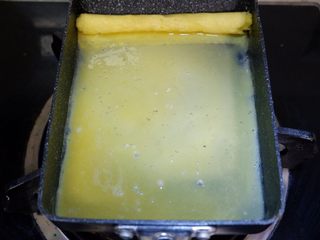 6、卡通狮子蛋烧便当「12」,在倒入2/3的蛋液，继续重复步骤5，6