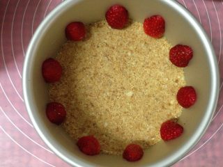 4、冻干草莓酸奶慕斯,将草莓去蒂从中间切开成两半，将冰箱中冷藏好的饼干底取出，摆放好草莓的位置