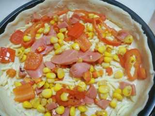 4、自制火腿披萨,将食材铺好饼皮上