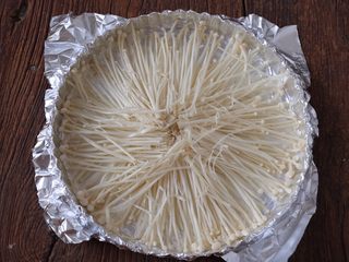 4、蒜蓉烤虾,将洗干净的金针菇平铺在烤盘内