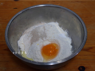 1、鸡胸肉肠仔披萨,面粉倒入大盆中，调入酵母、鸡蛋、盐、白糖拌匀