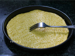 6、鸡胸肉肠仔披萨,将面皮放入刷好油的烤盘内，若面皮过大，除去余边，再用叉子或牙签在面皮表面戳出密集的小孔