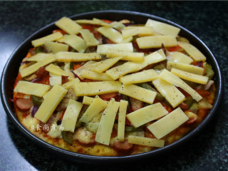 12、鸡胸肉肠仔披萨,取出，再铺上一层马苏里拉奶酪，撒下黑胡椒碎