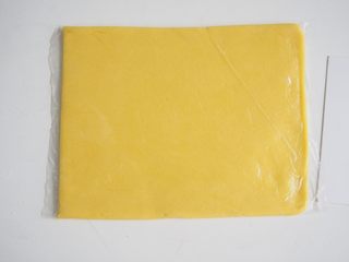 7、蛋黄奶酥,放入保鲜袋中擀成0.6cm左右厚度的薄片,放入冰箱冷冻1~2小时至硬