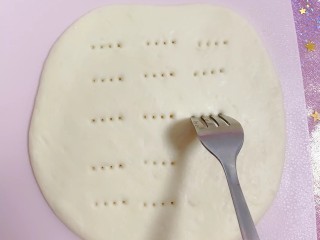5、芒果披萨,把面团擀成圆形用叉子扎眼。