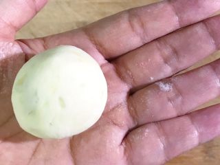 13、土豆糯米芝麻丸子,用大拇指和食指慢慢推上去包裹住，搓圆即可
