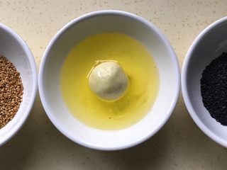 16、土豆糯米芝麻丸子,首先将丸子放进蛋液里滚一圈