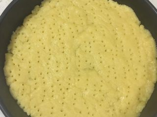 14、香甜的苹果派,擀好的派皮铺到派盘上（我用的是披萨盘）用手轻压派皮，使派皮紧贴在模具上，移去多余的派皮，并用牙签在派皮底上叉一些小孔。