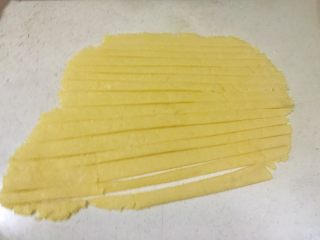 15、香甜的苹果派,将预留的小面团，用擀面杖擀成薄片，切成小长条。
