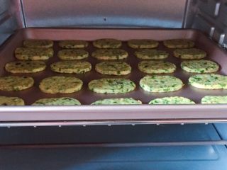 16、芝麻香葱饼干,将烤盘放入预热好的烤箱中层，上下火180度，烤18分钟，出炉晾凉即可。